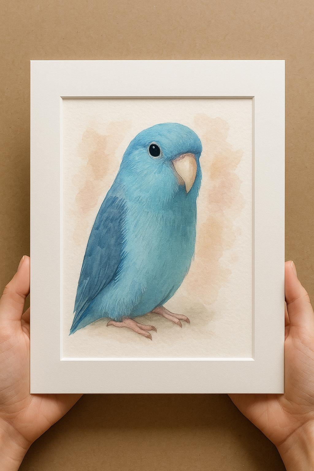 A person&#39;s hands are holding a white picture frame containing a watercolor painting of a blue parakeet.